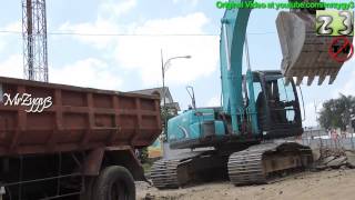 Excavator Kobelco SK200 Loading Worn Asphalt Into Dump Trucks [upl. by Alli]